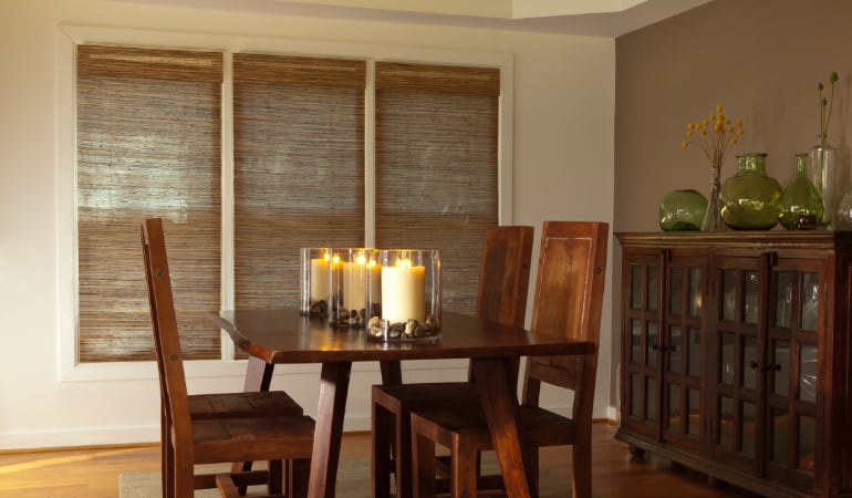 Woven shades in a dining room window.